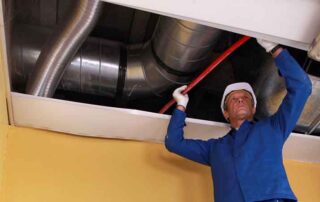 Technician installing HVAC ductwork in a ceiling, demonstrating proper preparation steps for professional air duct cleaning to ensure efficient airflow, improved indoor air quality, and optimal system performance before the cleaning process begins. - How to Prepare for Air Duct Cleaning
