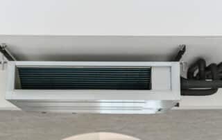 Ceiling-mounted air conditioning unit with exposed pipes