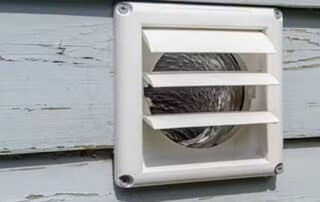 Exterior dryer vent on house siding